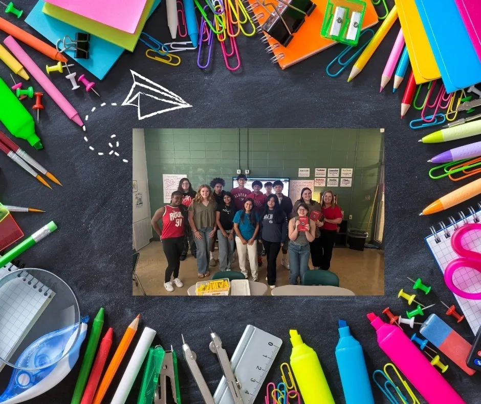 Students posing in classroom with stationery border.