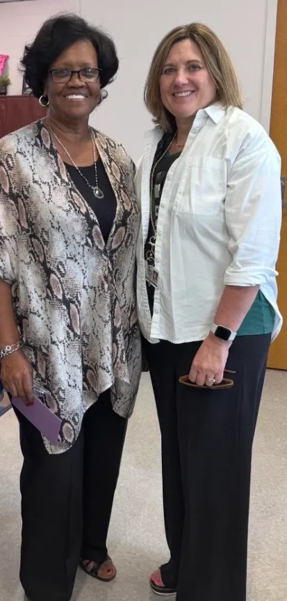 Two women standing together, smiling