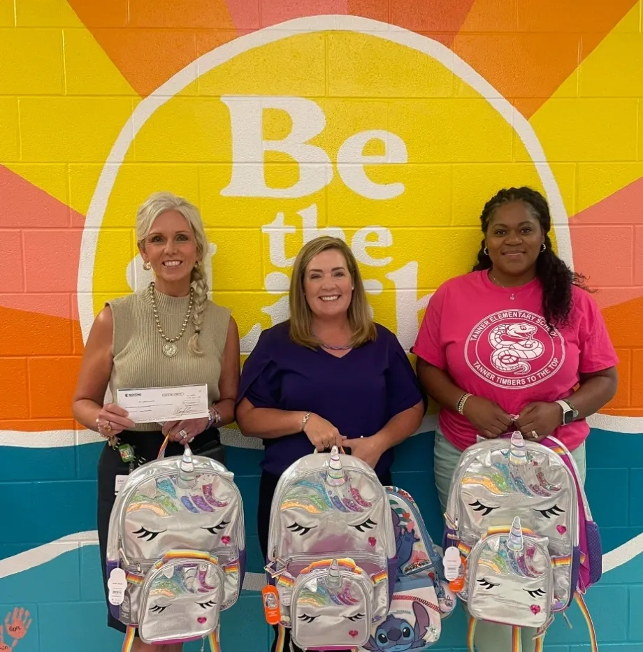 Group posing with backpacks against colorful wall