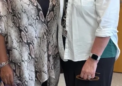 Two women standing together, smiling