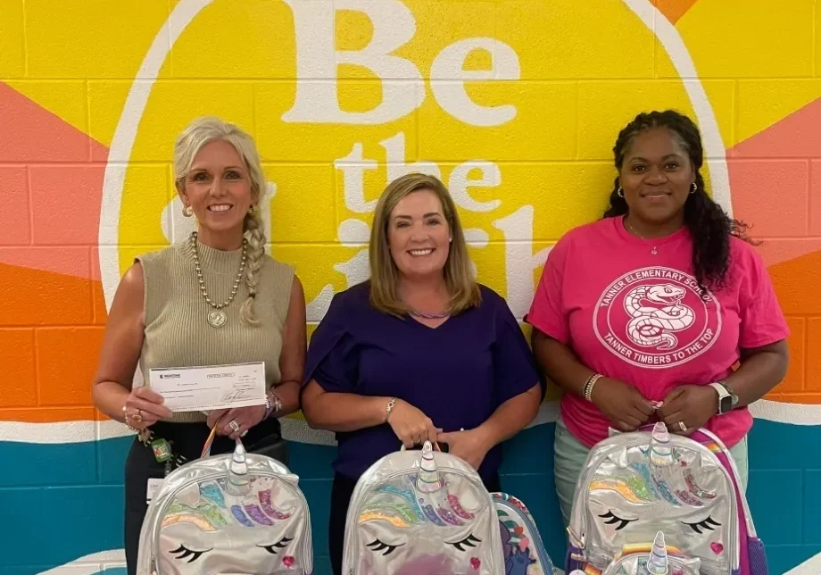 Group posing with backpacks against colorful wall
